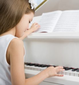 Kind übt am Klavier